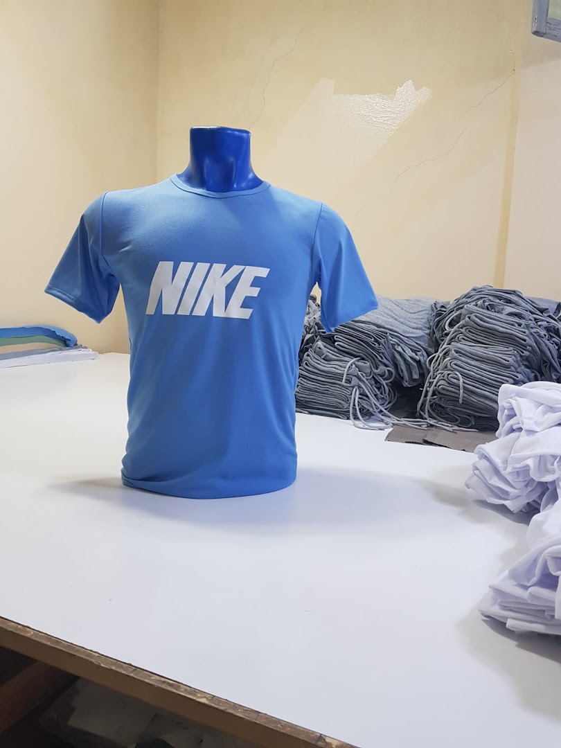 A blue Nike t-shirt displayed on a mannequin, surrounded by stacks of apparel.