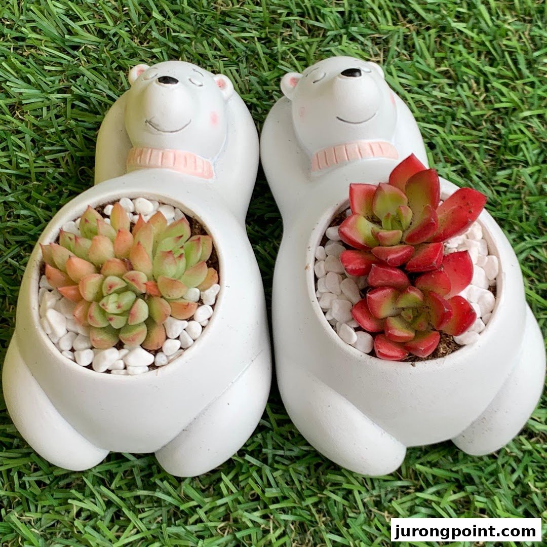Two adorable bear planters with vibrant succulents on a green grass background.