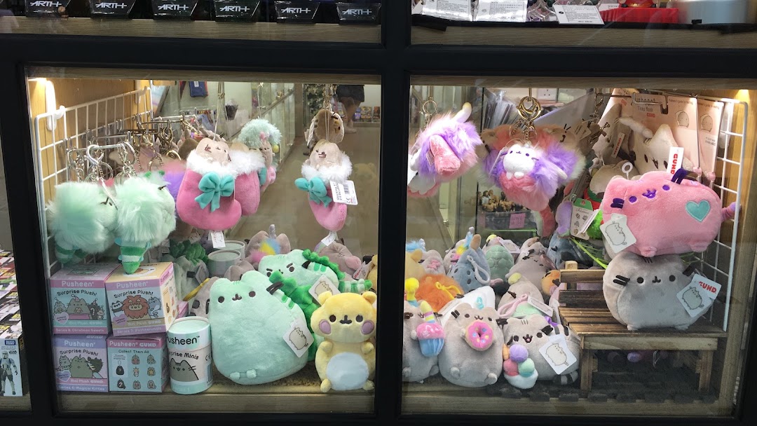 A display case filled with various cute plush toys and keychains, including many Pusheen characters.