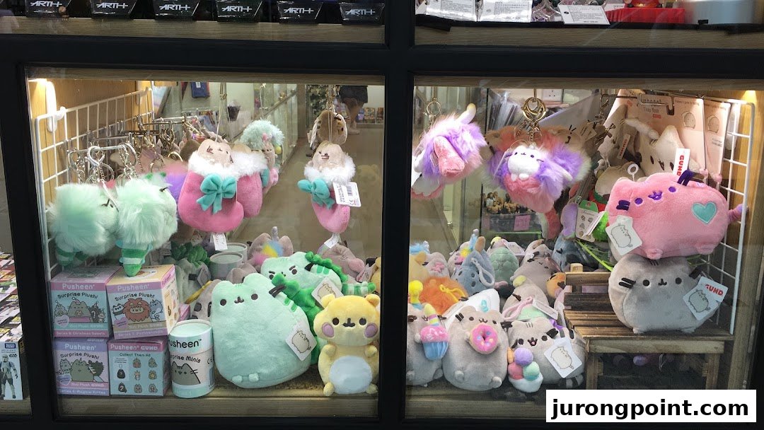 A display case filled with various cute plush toys and keychains, including many Pusheen characters.