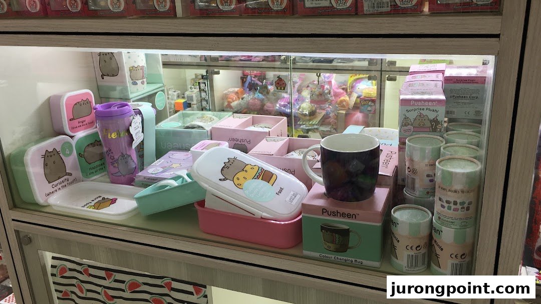 A display case at Hako featuring various Pusheen merchandise like lunchboxes, mugs, and collectible figures.