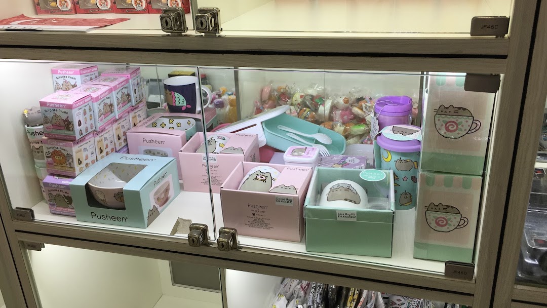 A display case at Hako filled with various Pusheen-themed merchandise, including plush toys, bowls, and mugs.