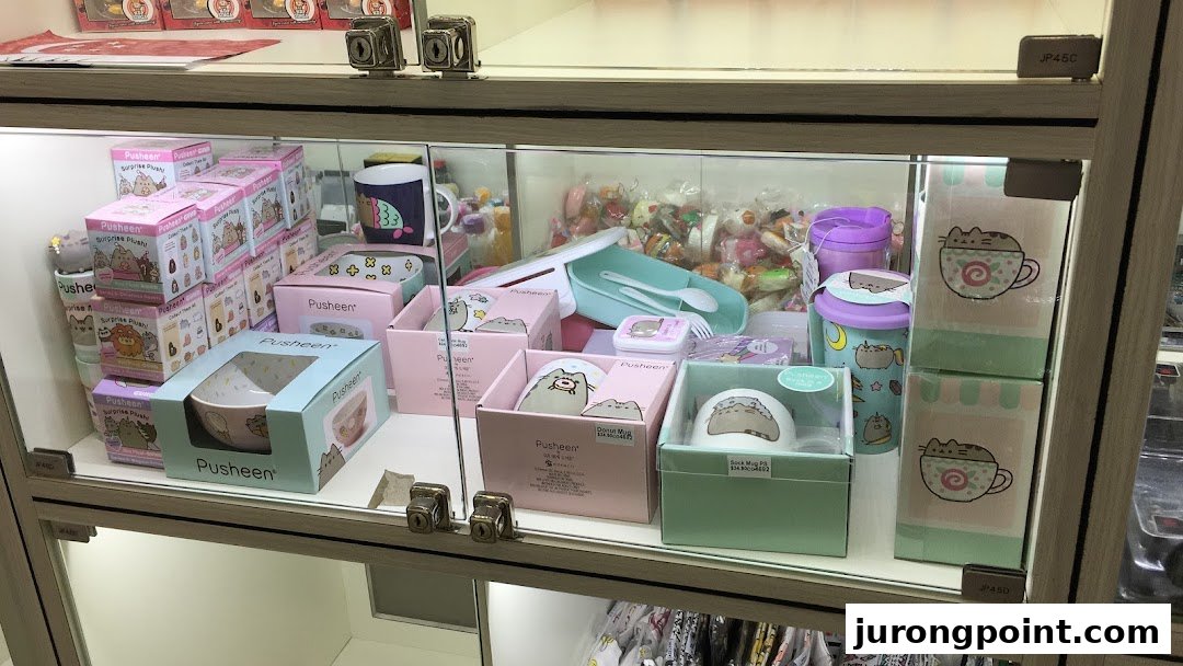 A display case at Hako filled with various Pusheen-themed merchandise, including plush toys, bowls, and mugs.