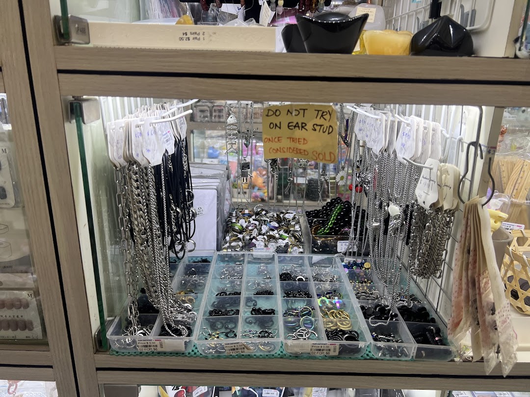 A retail display case showcasing various fashion accessories, including necklaces, rings, and ear studs.