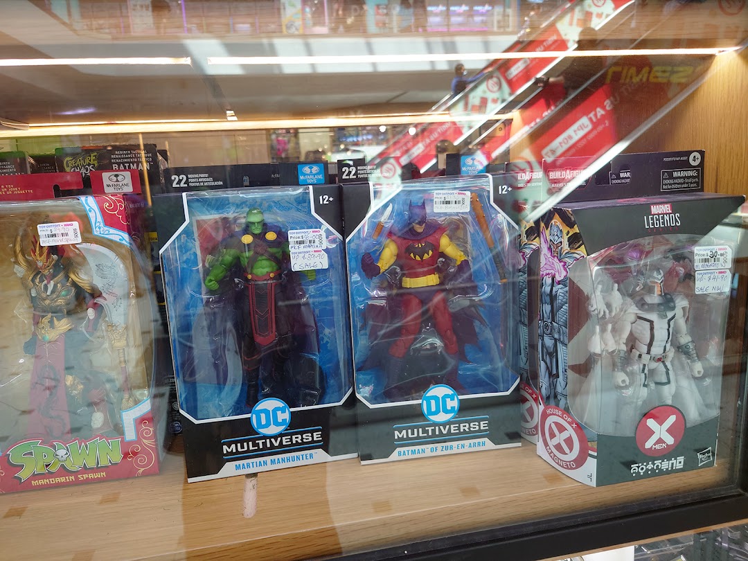A display case showcasing various collectible action figures from popular franchises like DC, Marvel, and Spawn.