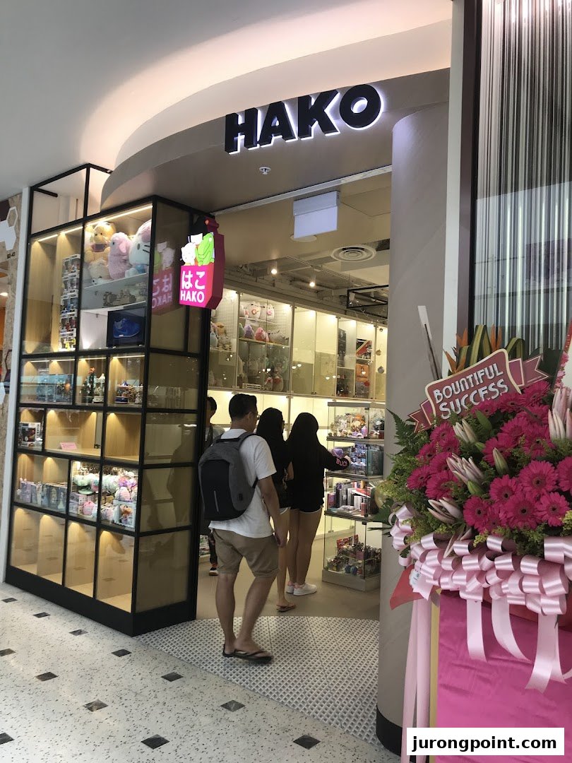 The Hako shop entrance, featuring its signage, display cases, and customers entering.