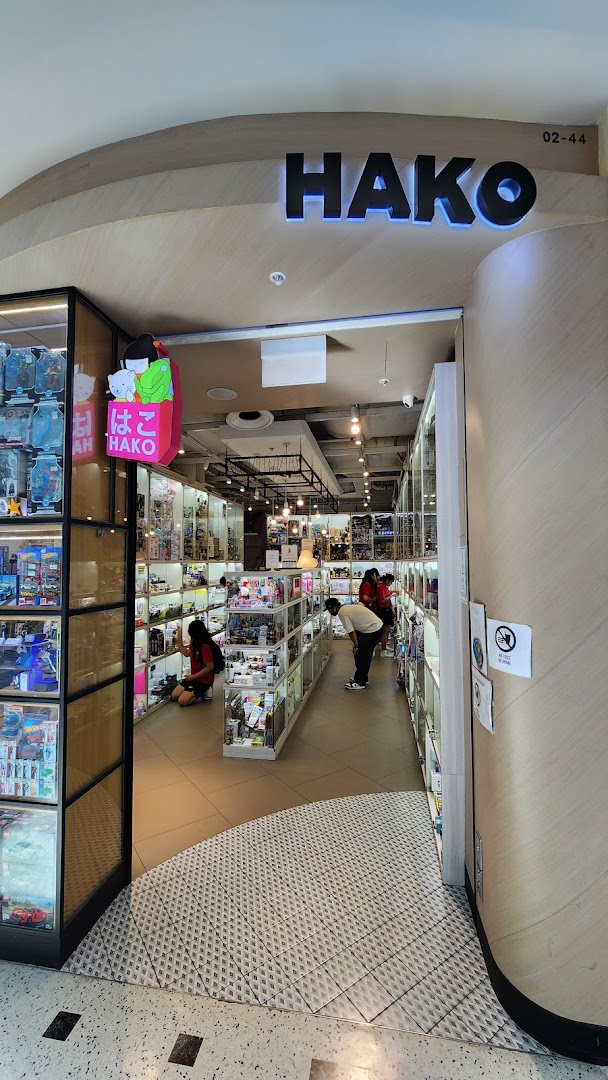 The Hako shop entrance features display cases filled with collectibles and toys, with customers browsing inside.