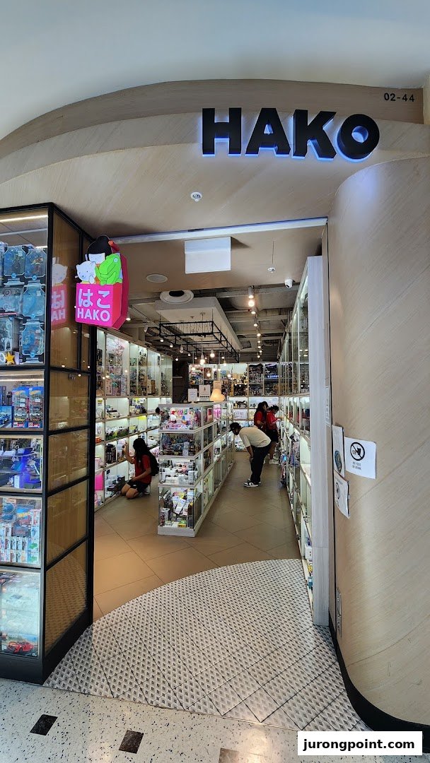 The Hako shop entrance features display cases filled with collectibles and toys, with customers browsing inside.