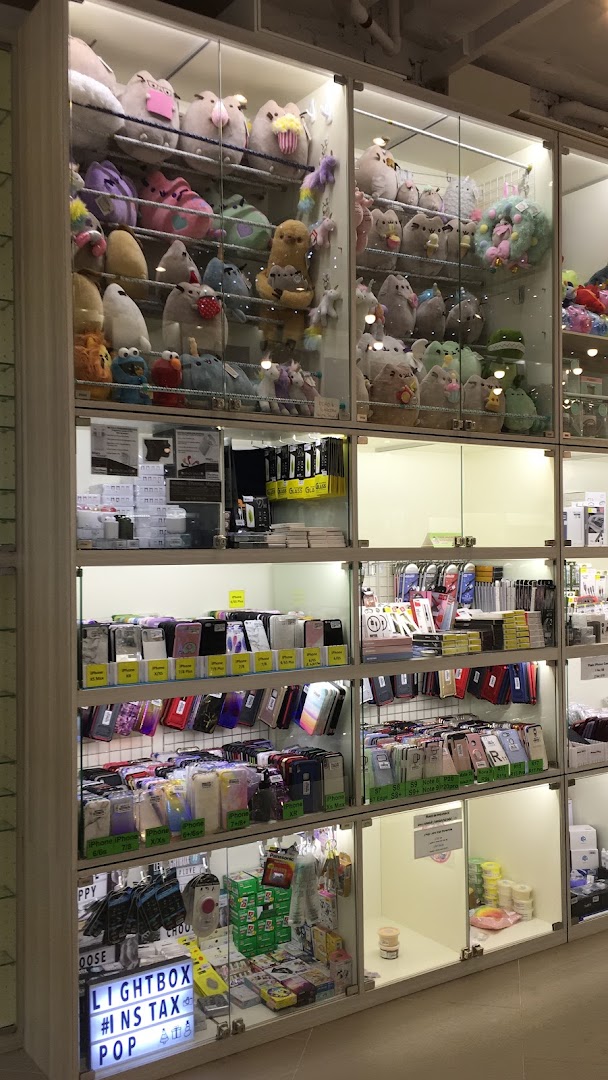 Multiple glass display cases filled with plush toys, phone accessories, and novelty items inside a retail store.