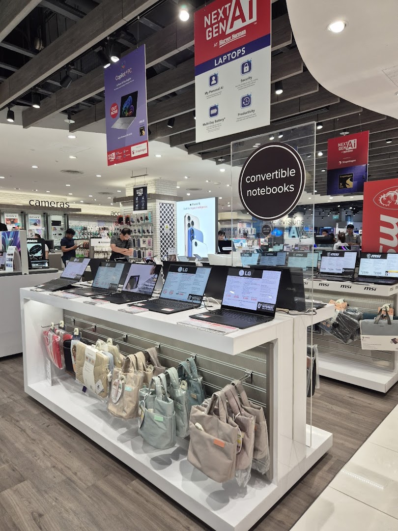 An interior shot of Harvey Norman showcasing a wide range of laptops, convertible notebooks, and tech accessories.