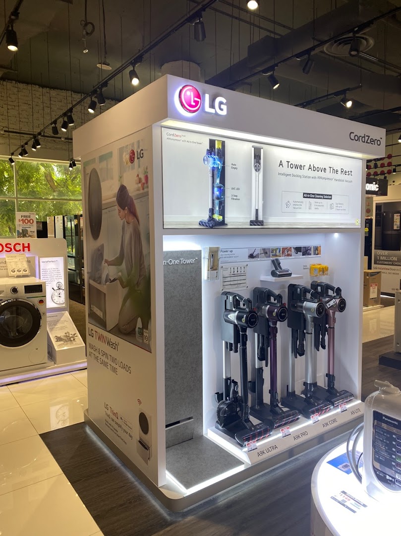 An LG display showcasing CordZero vacuum cleaners and a TwinWash washing machine at Harvey Norman.