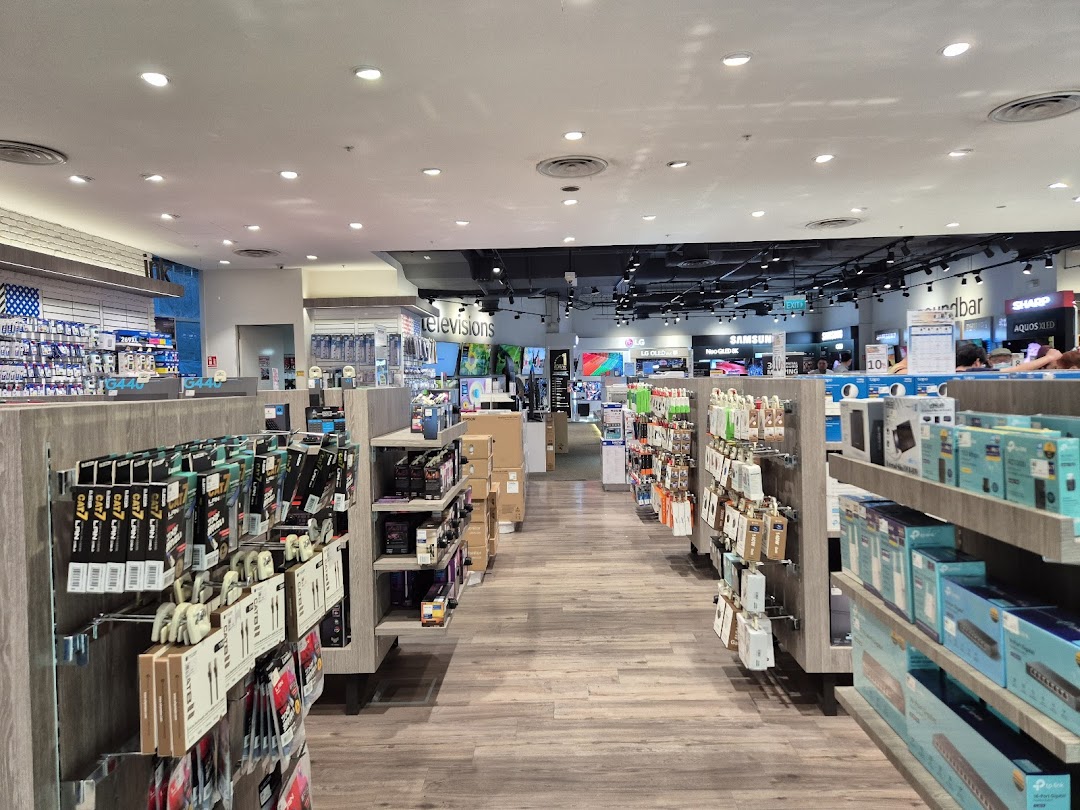 An interior view of Harvey Norman, showcasing aisles filled with electronics, accessories, and home appliances.