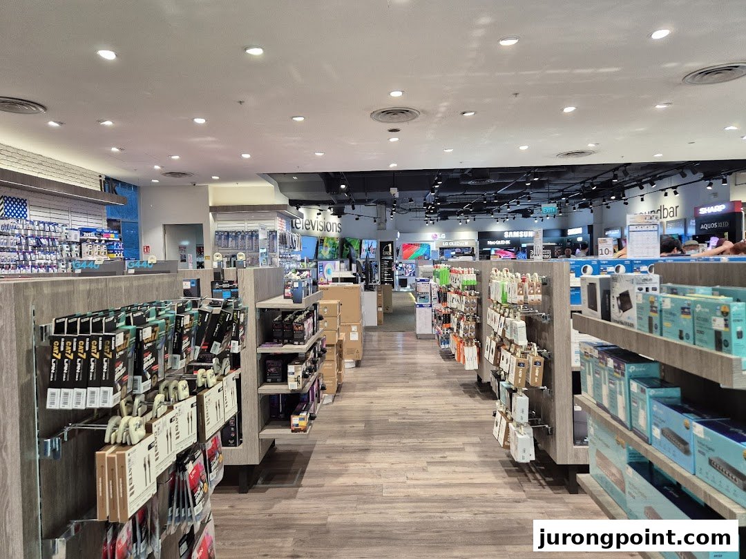 An interior view of Harvey Norman, showcasing aisles filled with electronics, accessories, and home appliances.