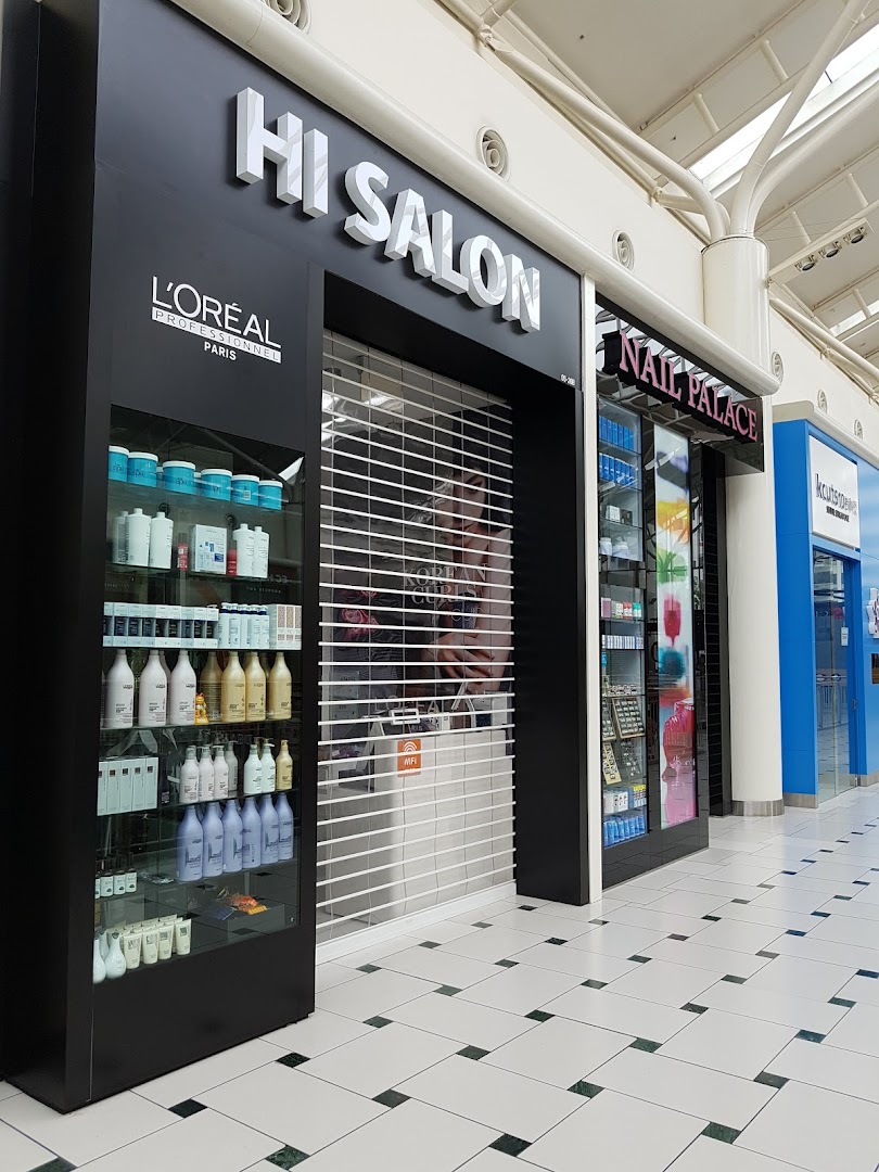 The shop front of HI Salon, featuring L'Oréal products on display and a closed security shutter.