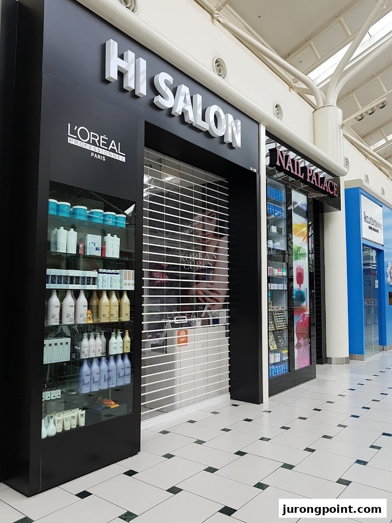 The shop front of HI Salon, featuring L'Oréal products on display and a closed security shutter.