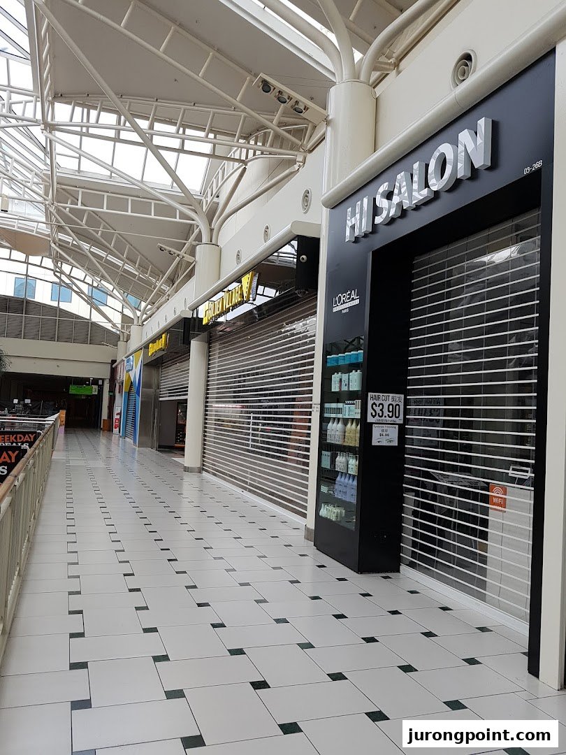 The closed storefront of HI Salon, a hair salon, located within a shopping mall corridor.