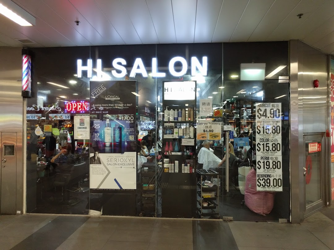 Exterior view of HI Salon, a hair and beauty salon, with service prices displayed on the glass.