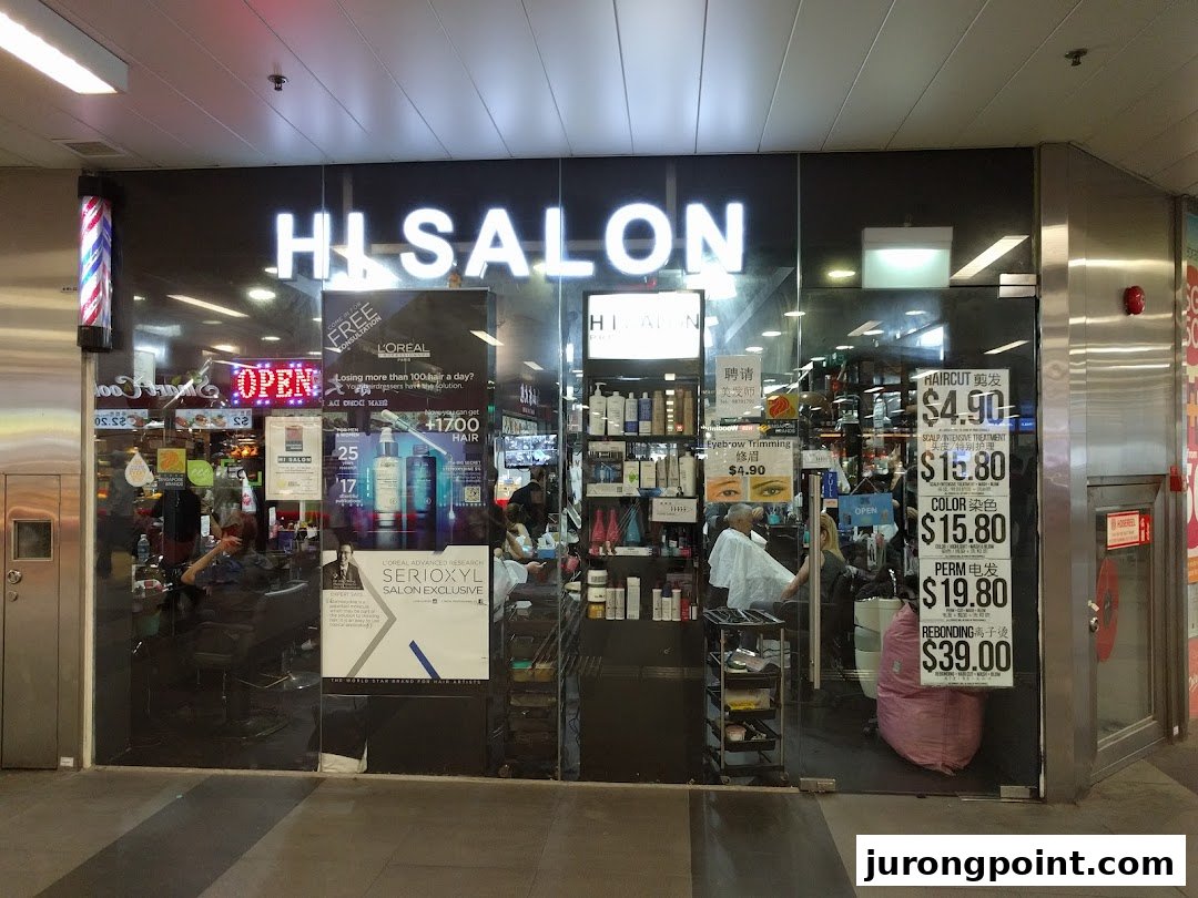 Exterior view of HI Salon, a hair and beauty salon, with service prices displayed on the glass.