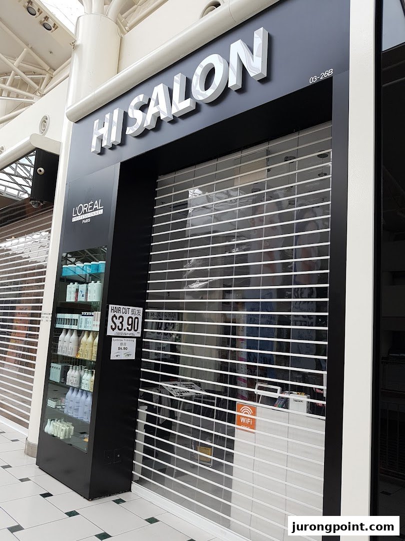 The exterior of HI Salon, a hair salon, with its security shutter closed and product display.