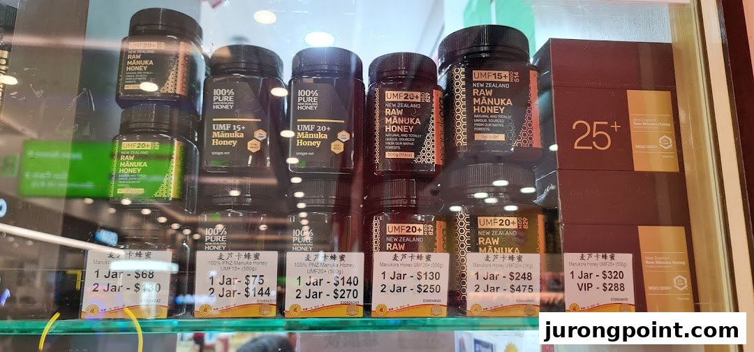 A display shelf showcasing various grades of New Zealand Manuka honey products with their prices at Hockhua Tonic.