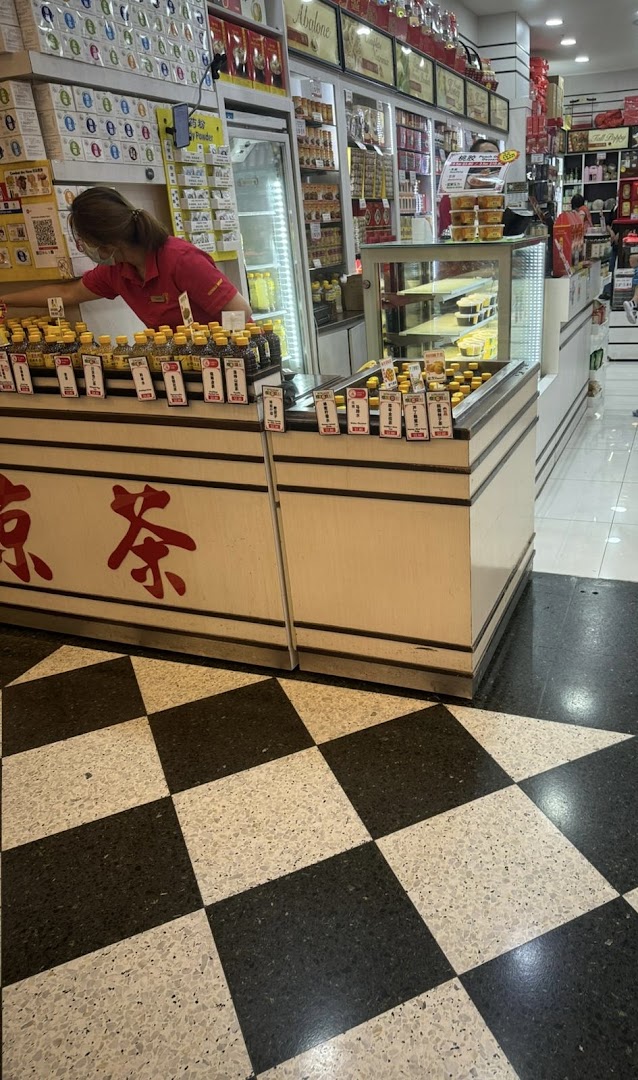 A staff member arranges health products on a display counter inside Hockhua Tonic.
