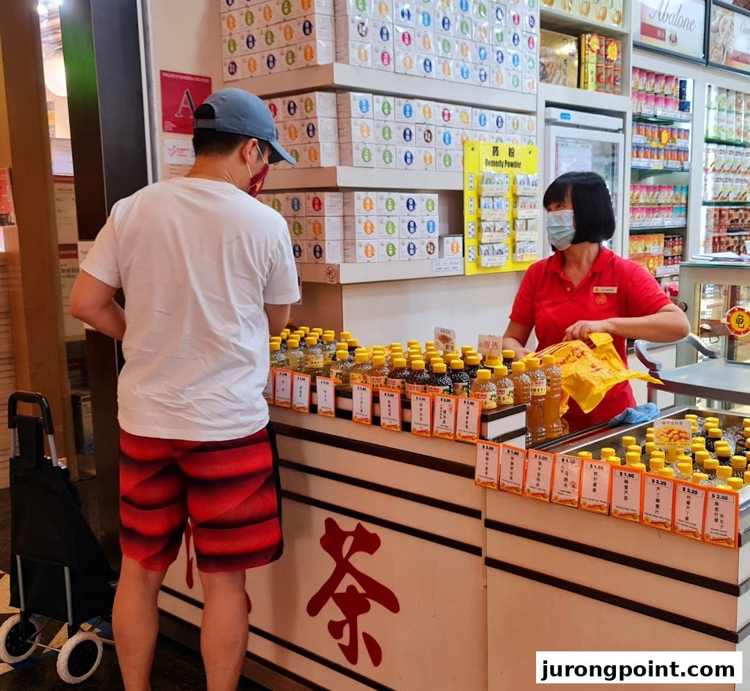 A customer interacts with a staff member at a counter displaying various bottled tonics and traditional remedies.