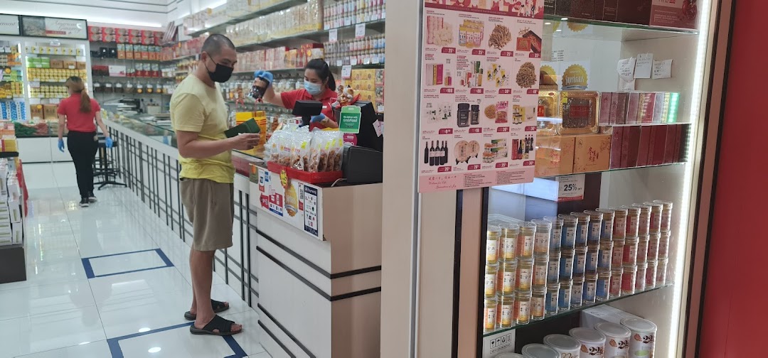 Customers browse and purchase traditional health products at Hockhua Tonic, featuring a promotional display.