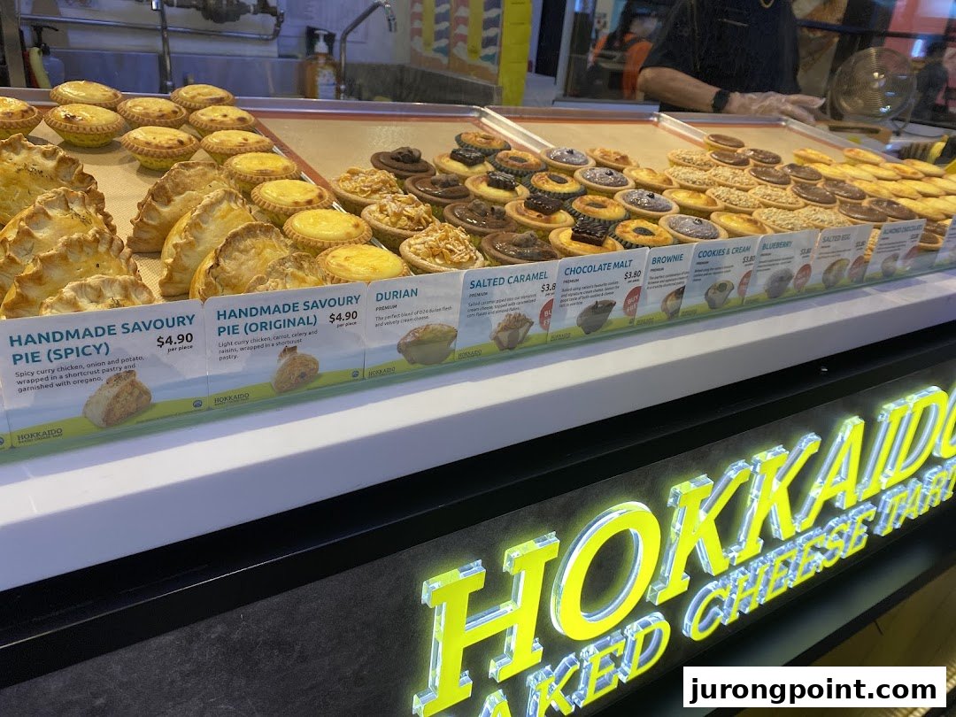 A vibrant display counter showcasing a variety of delicious tarts and pies with visible pricing.
