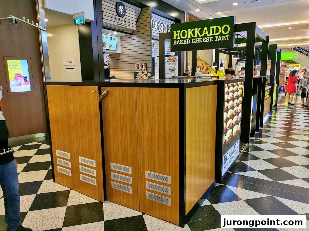A kiosk for Hokkaido Baked Cheese Tart in a mall, featuring its branding and product display.