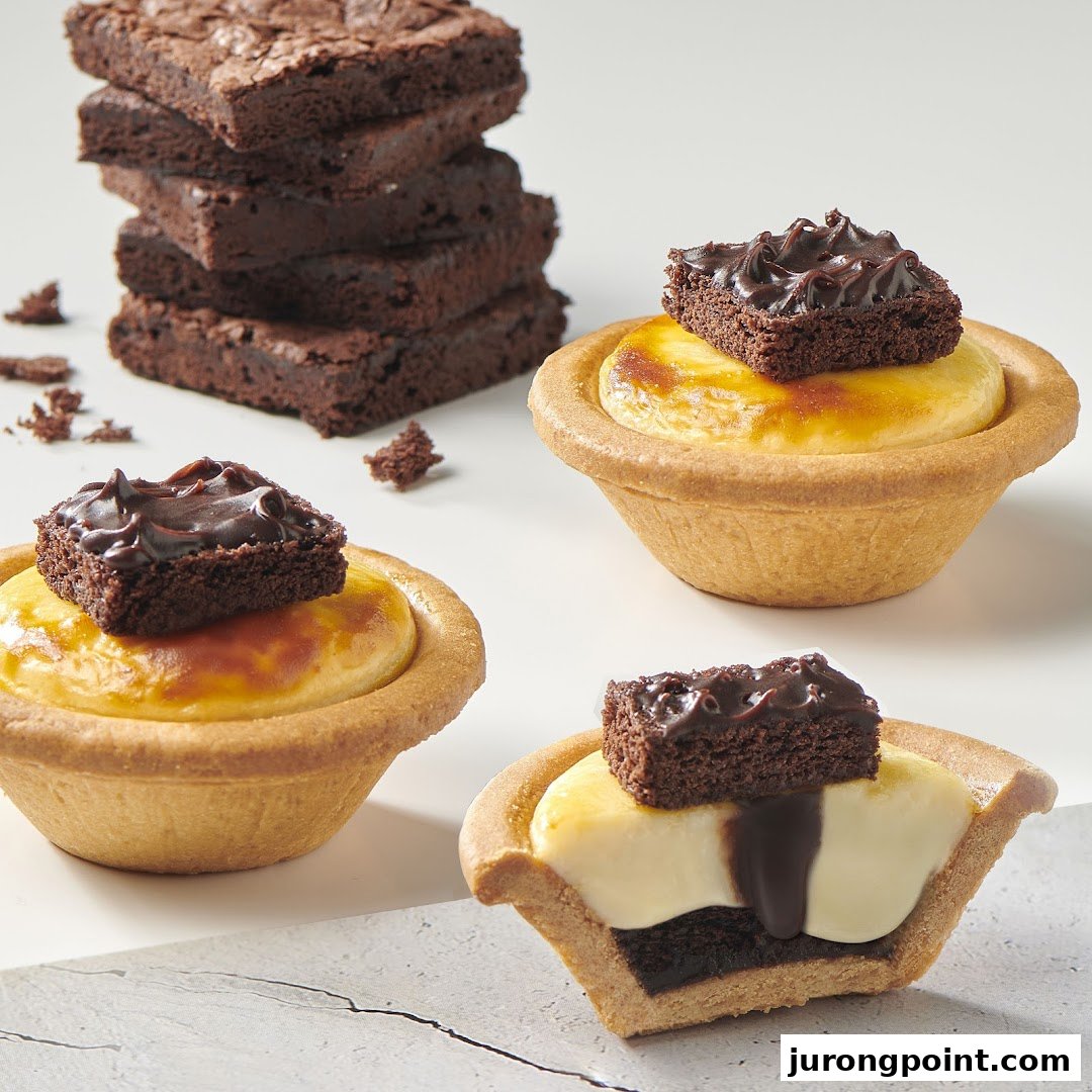 Delicious cheese tarts topped with brownies, alongside a stack of rich chocolate brownies.
