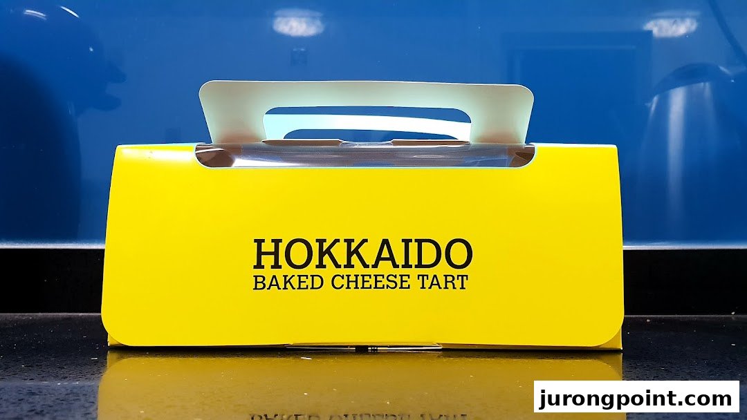 A bright yellow box for Hokkaido Baked Cheese Tart, featuring the brand name prominently.