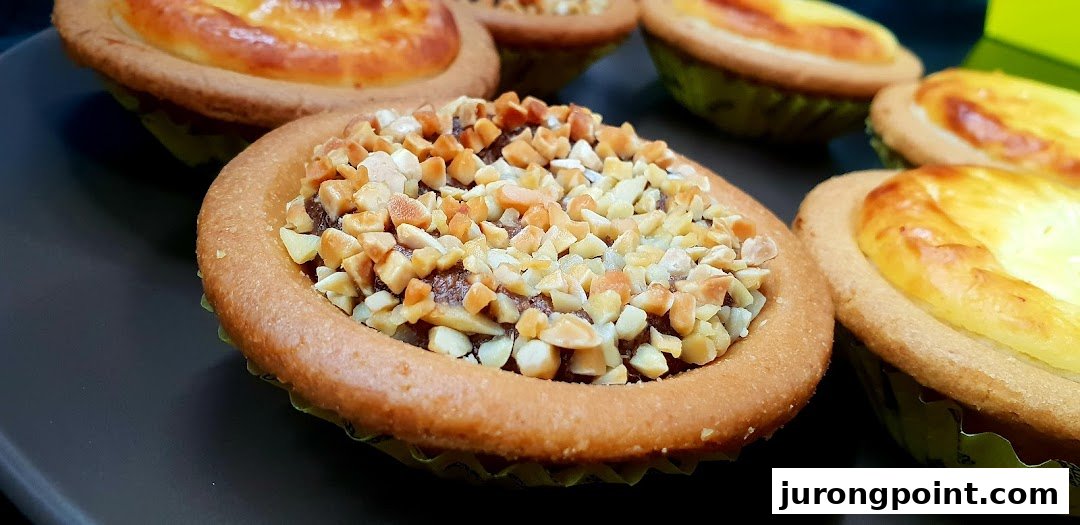 Close-up of various Hokkaido Baked Cheese Tarts, including a chocolate and nut flavor.