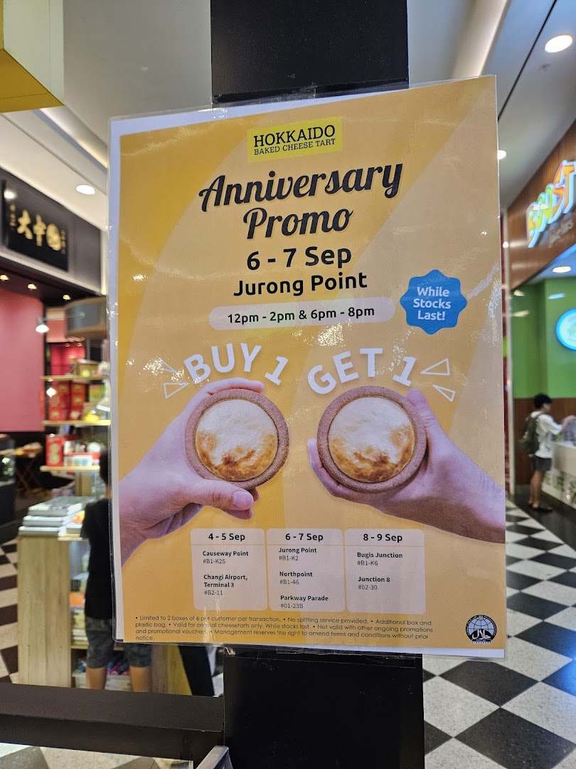 A promotional poster for Hokkaido Baked Cheese Tart's anniversary 'Buy 1 Get 1' offer on cheese tarts.