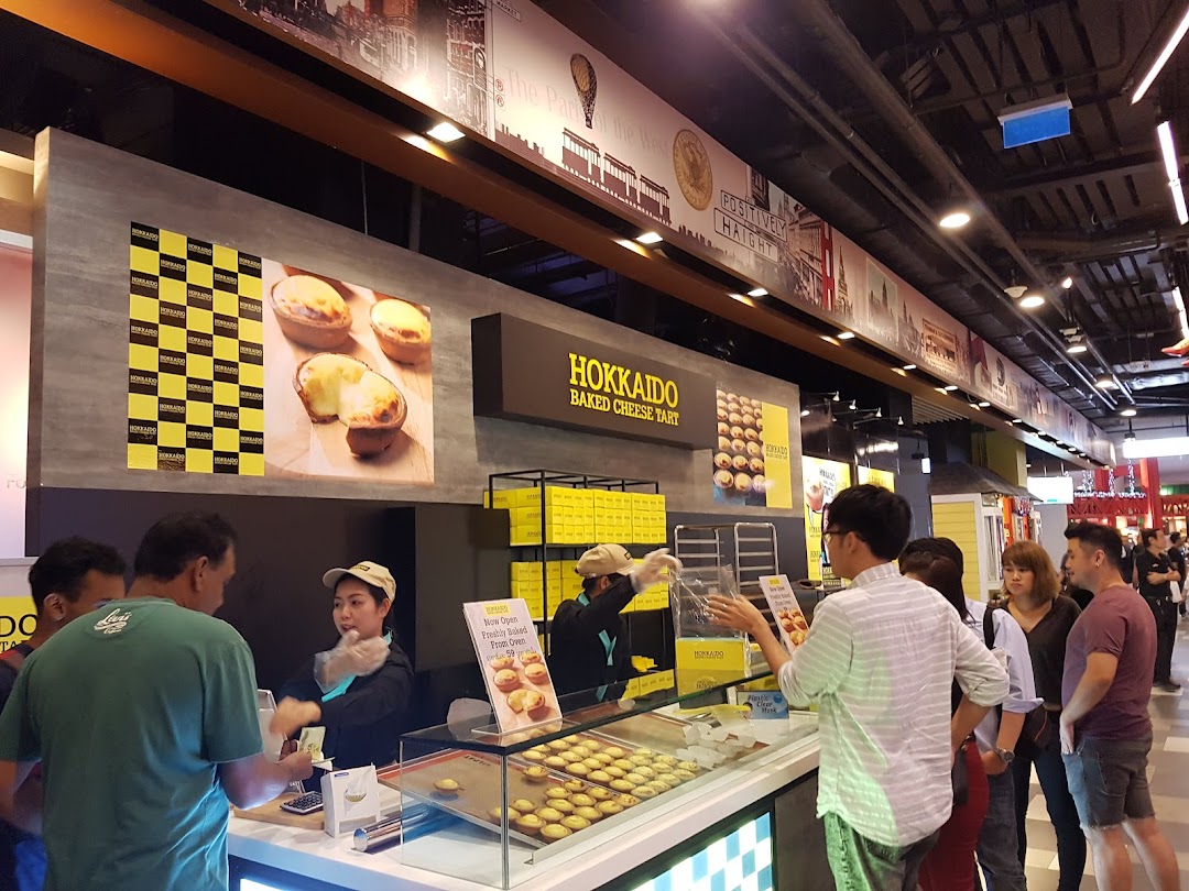 Customers queueing at the Hokkaido Baked Cheese Tart counter, featuring freshly baked tarts on display.
