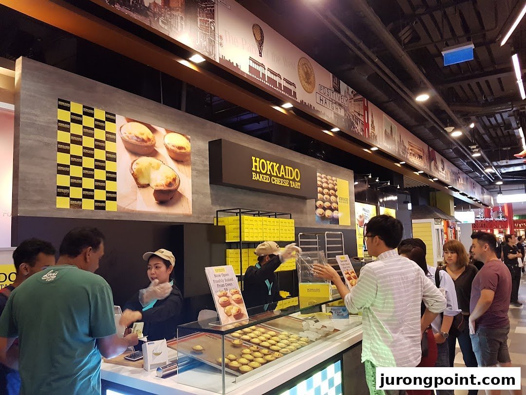 Customers queueing at the Hokkaido Baked Cheese Tart counter, featuring freshly baked tarts on display.
