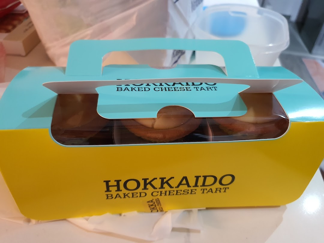 A vibrant yellow and blue box of Hokkaido Baked Cheese Tarts, ready for enjoyment.