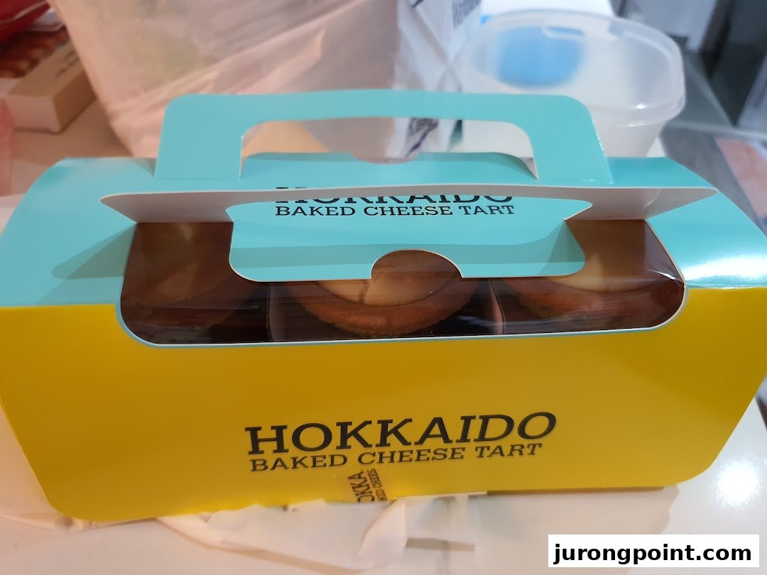 A vibrant yellow and blue box of Hokkaido Baked Cheese Tarts, ready for enjoyment.