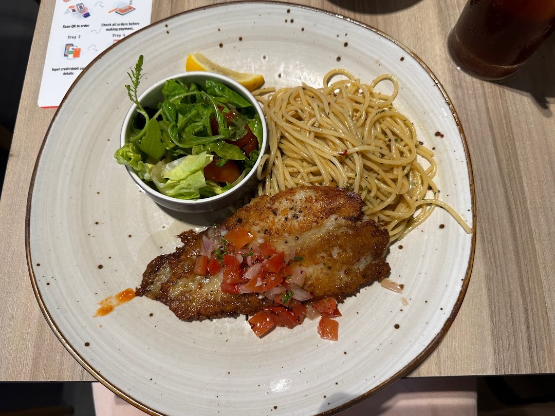 A plate of pan-fried fish with salsa, spaghetti, and a side salad, served at Hot Tomato.