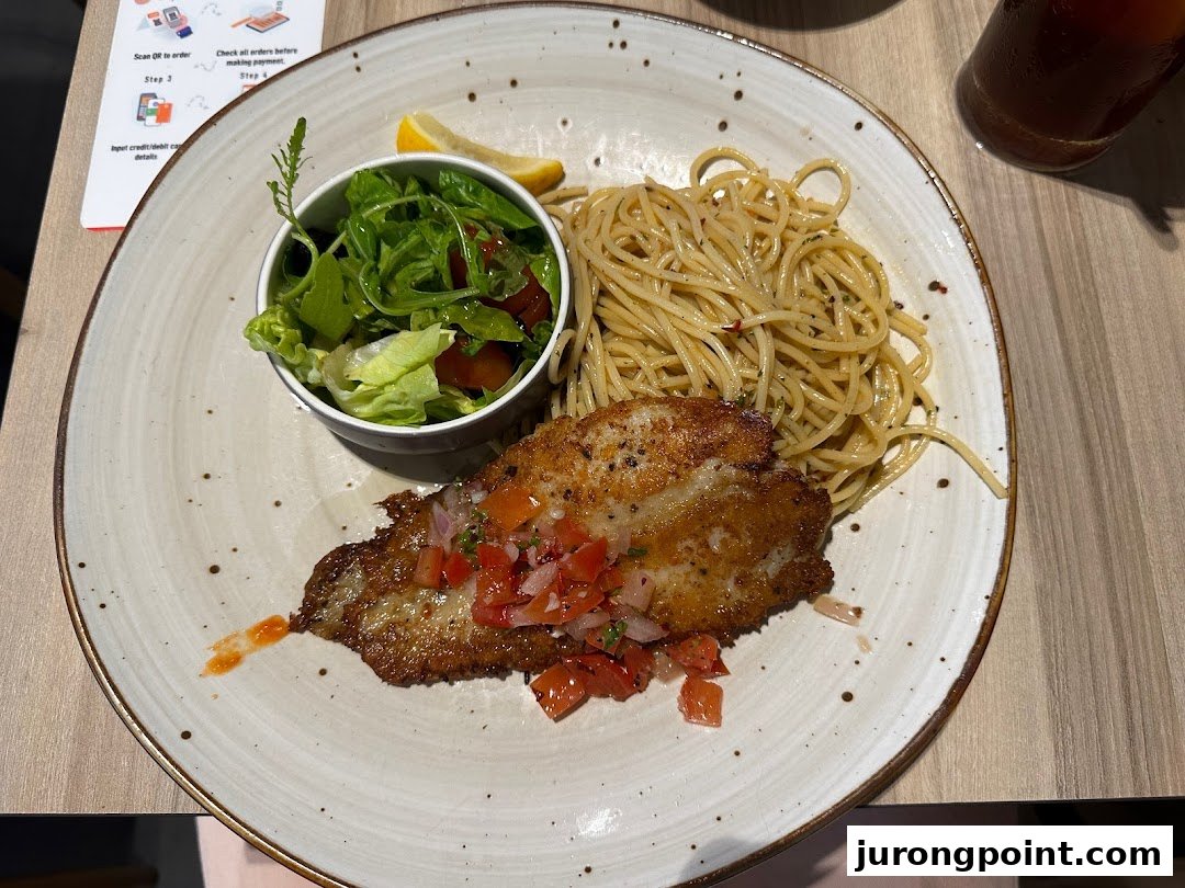 A plate of pan-fried fish with salsa, spaghetti, and a side salad, served at Hot Tomato.