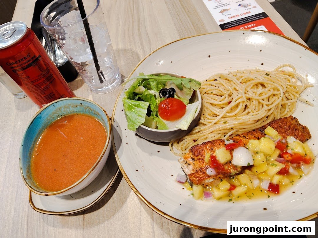 A delicious meal featuring salmon with salsa, spaghetti, fresh salad, and a side of soup.