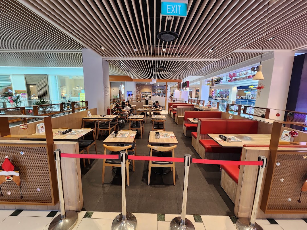 Spacious interior of Hot Tomato restaurant featuring dining tables, red booths, and festive decor.