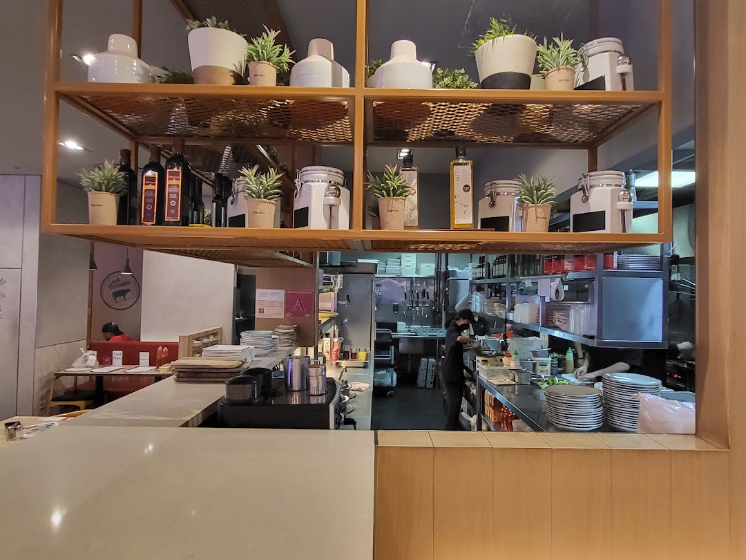 An interior view of Hot Tomato, showcasing its open kitchen, counter, and decorative shelving.