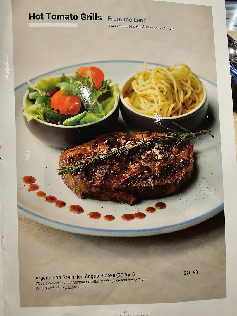 A menu page showcasing a grilled Argentinian Angus Ribeye steak with salad and spaghetti.