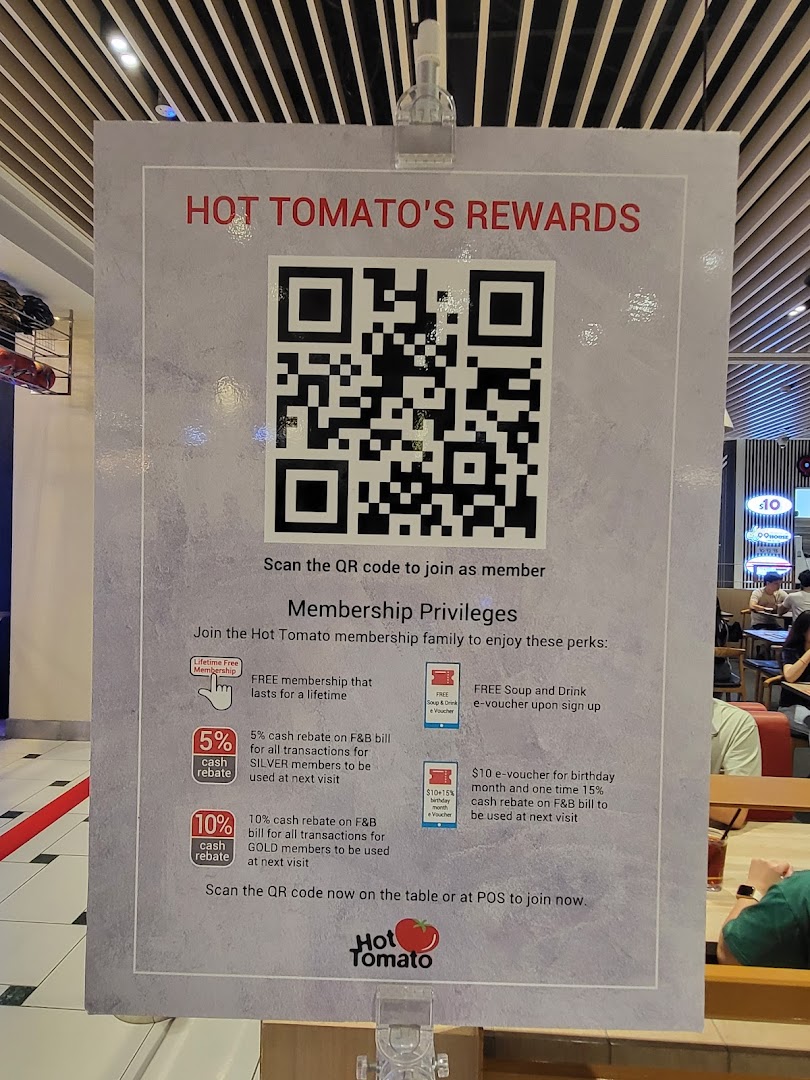 A sign for Hot Tomato's rewards program, displaying membership benefits and a QR code.