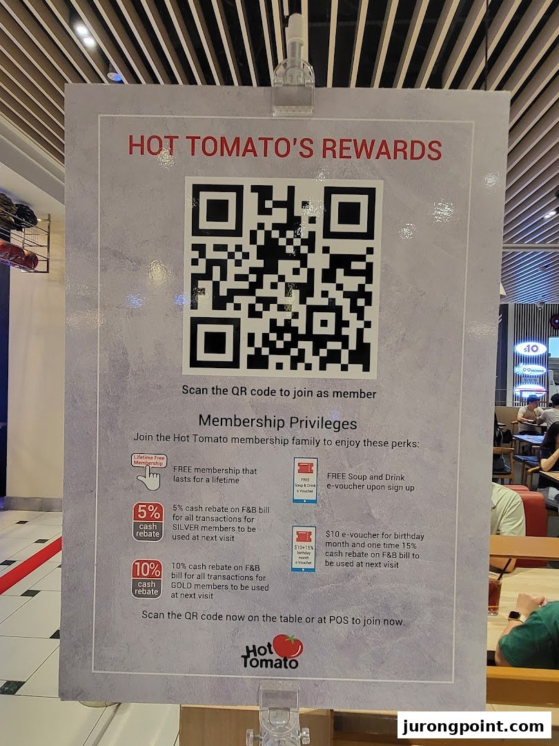 A sign for Hot Tomato's rewards program, displaying membership benefits and a QR code.