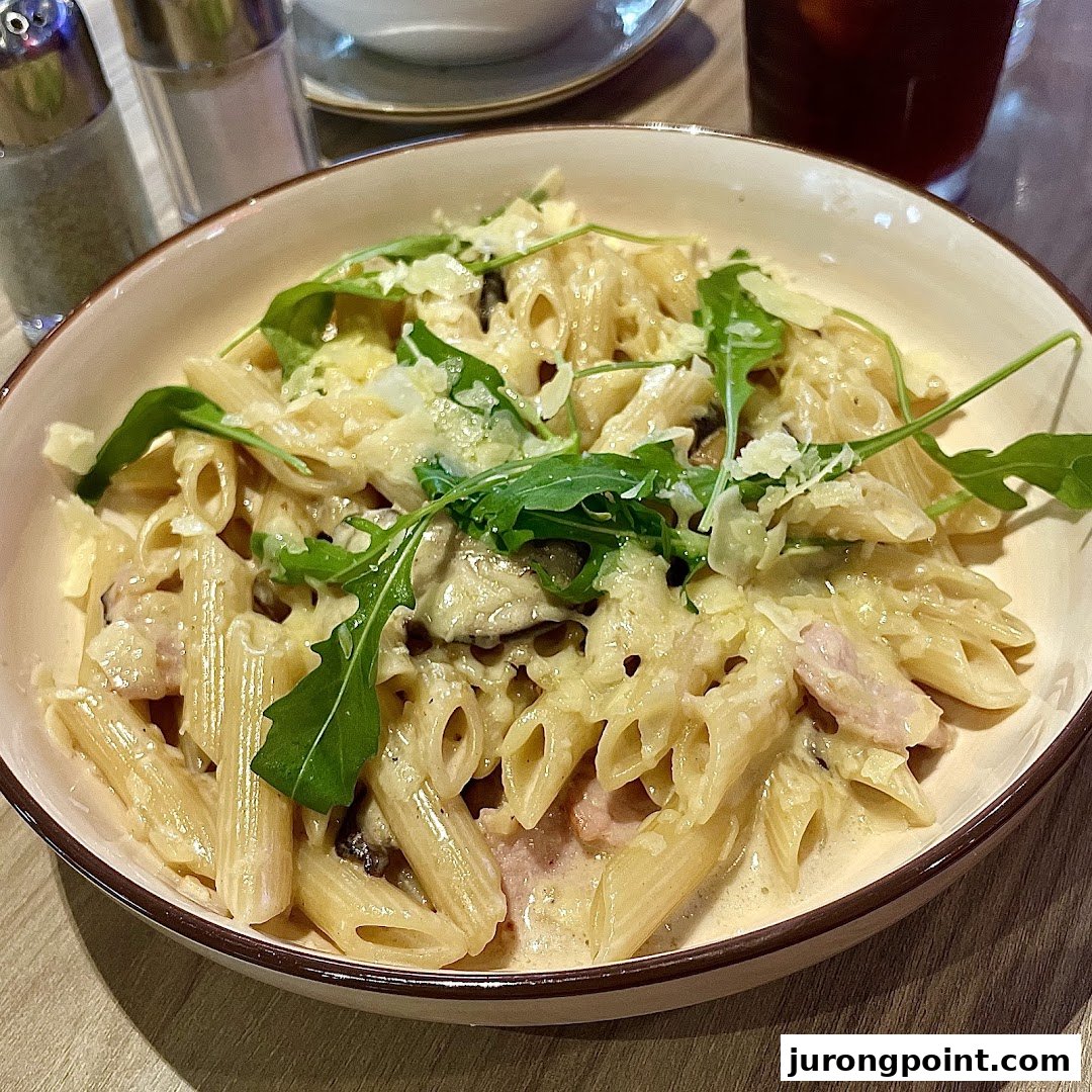 A creamy pasta dish with penne, mushrooms, bacon, parmesan, and arugula.