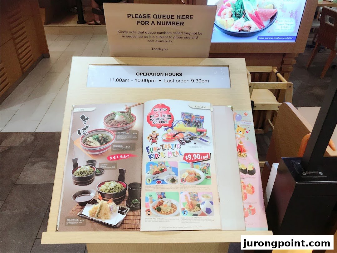 A stand at Ichiban Boshi displaying menu items, operating hours, and queuing instructions.