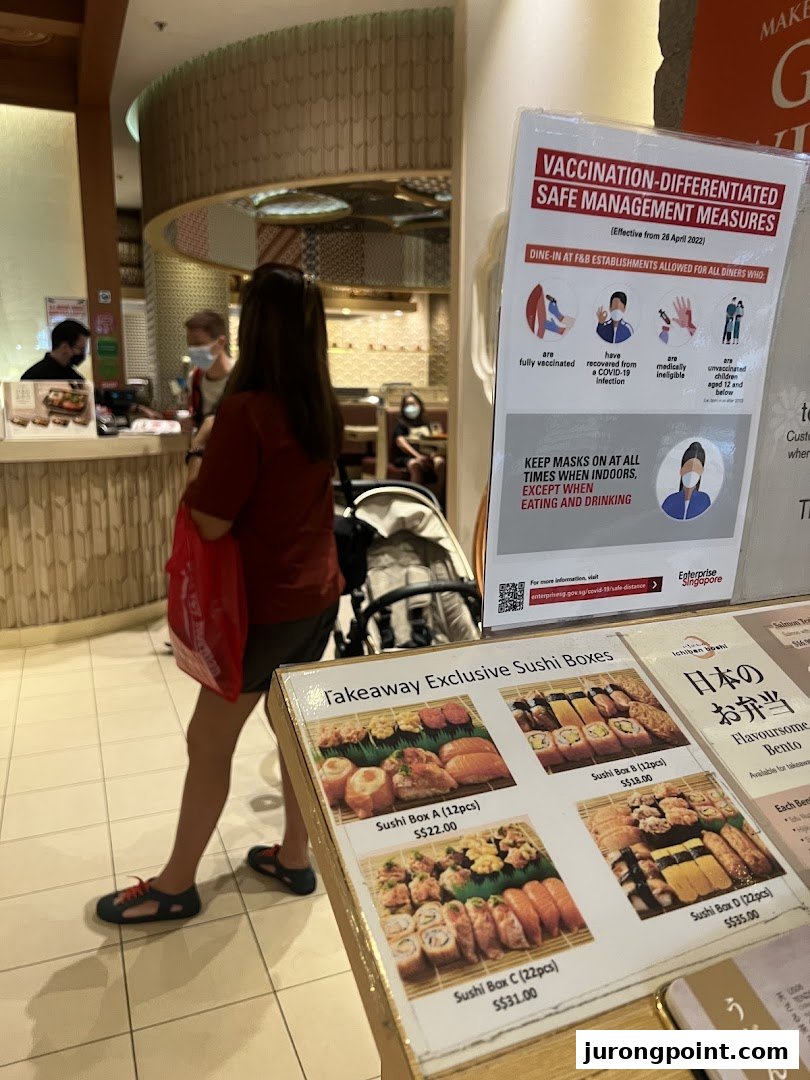 A display board at Ichiban Boshi showcasing takeaway sushi boxes and bento options with prices.