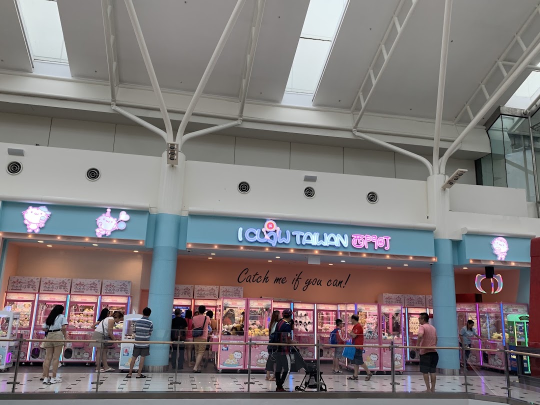 The storefront of iClaw Taiwan, featuring numerous claw machines and people playing them.