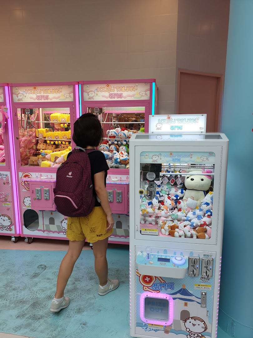 A person stands before colorful claw machines filled with various plush toys at iClaw Taiwan.
